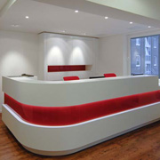 Rote Akzente: beleuchteter Empfangstresen aus Mineralwerkstoff und Schrank (Entwurf: Maria Levy/Foto: Susanne Feyll)