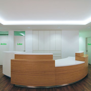 Mit Sitzstufe für Kinder: Empfangstresen aus Mineralwerkstoff und Eiche (Entwurf: Maria Levy/Foto: Susanne Feyll)