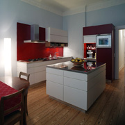 Weiß und Edelstahl aber warm: Spritzschild und Rückwände rot lackiert (Foto: Bernd Grundmann)